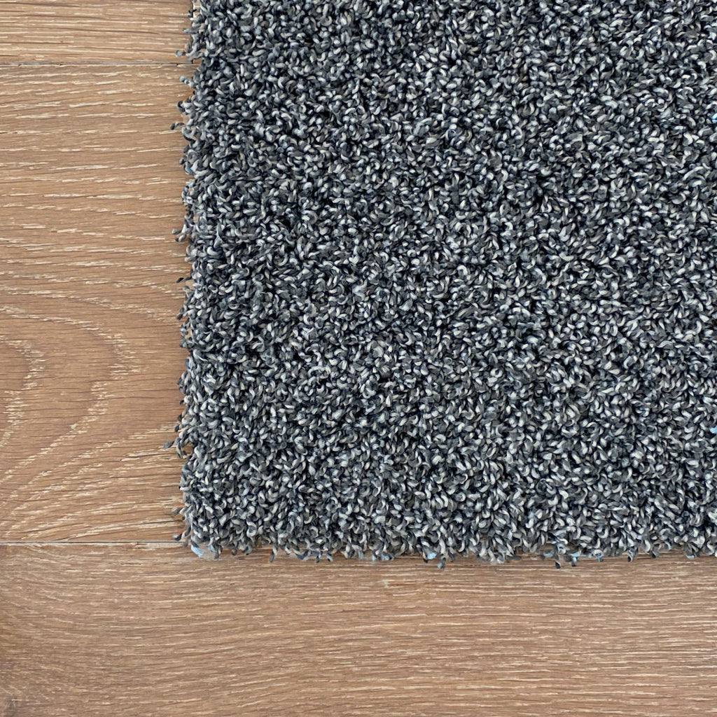 Close-up of gray carpet on a wooden floor. Machine washable LCT carpet tiles squares DIY